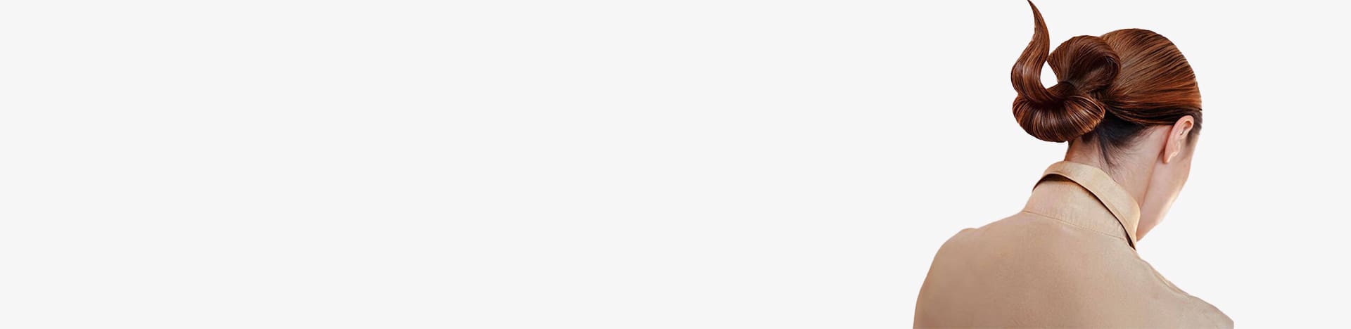 A woman with red hair styled in an elegant twisted bun, wearing a beige collared shirt, shown from the back.