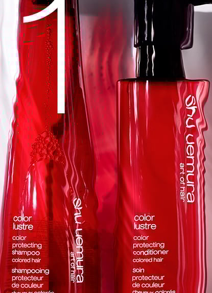 Red bottles of Shu Uemura Color Lustre shampoo and conditioner for protecting colored hair.