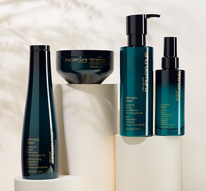 Shu Uemura Ultimate Reset hair care products arranged on concrete blocks.